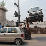 a crane towing a car in sialkot, pakistan