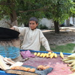 Child street vender in Pakistan selling corn